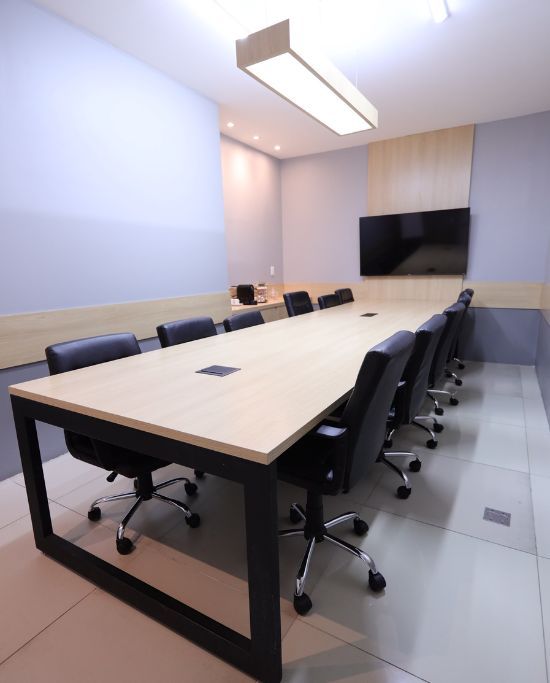 Sala de reuniões com mesa grande e televisão